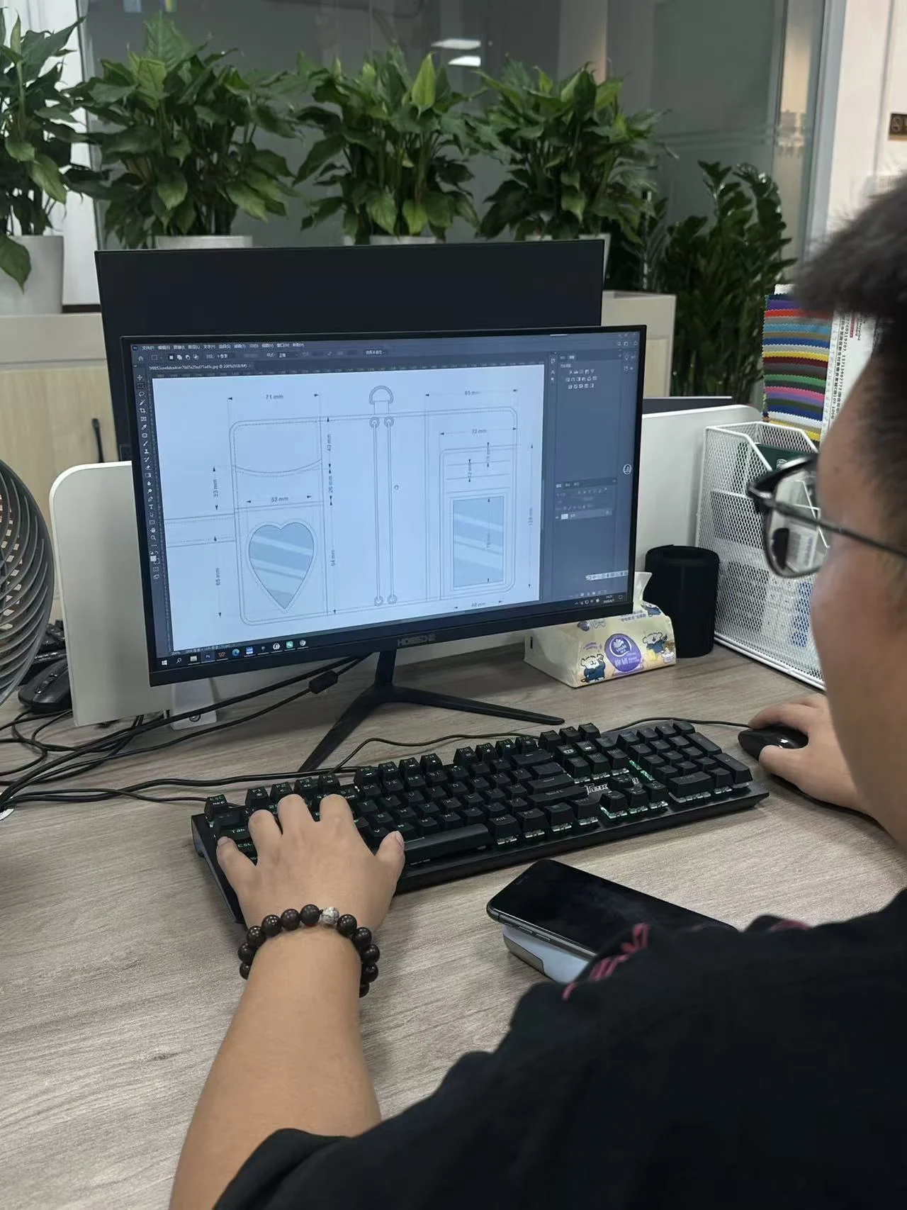 Custom bag design and technical specification review Hongzhao designer reviewing a custom bag technical drawing on a computer