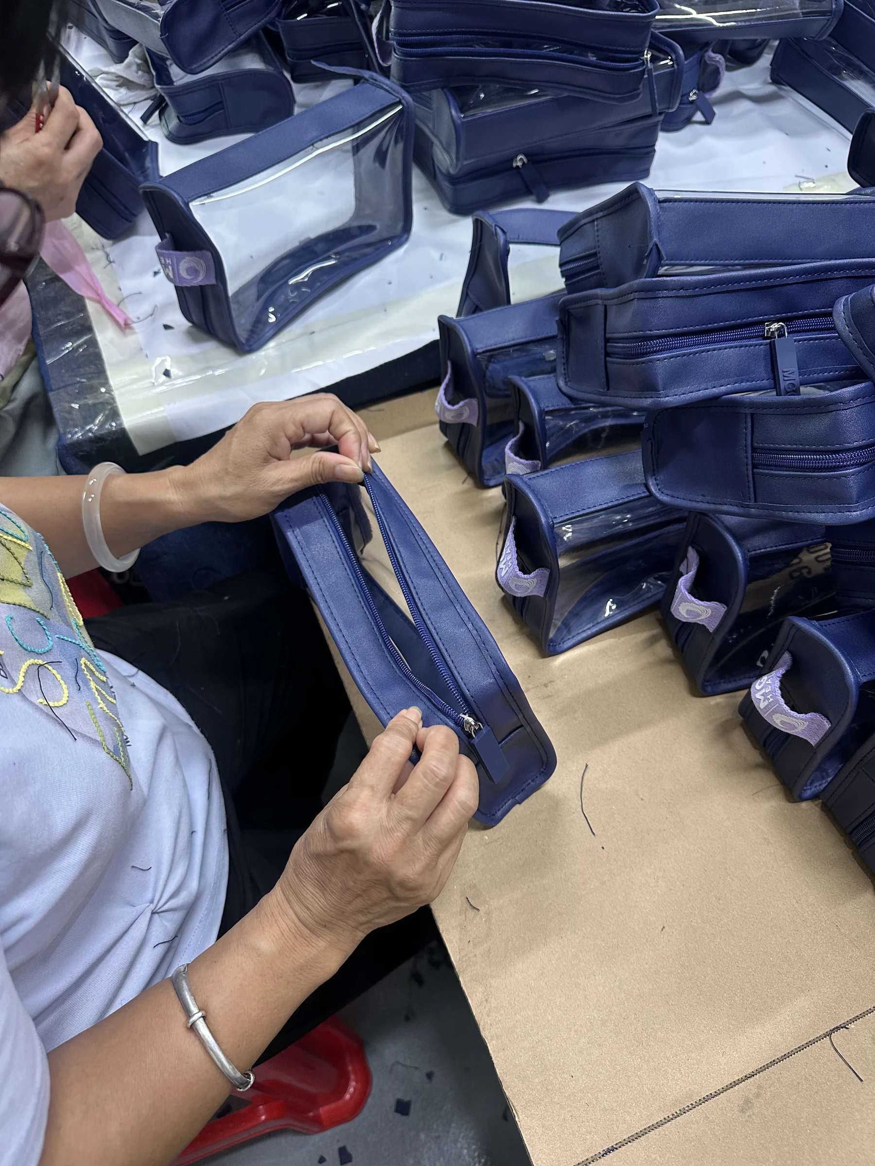 Finished-bag inspection Real Hongzhao inspector checking zipper function and workmanship on finished custom cosmetic bags